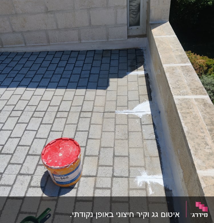 דלי צבע וכלי עבודה לאיטום על רצפה מרוצפת